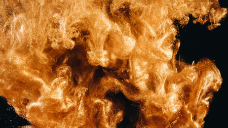 Ink in water. Colour golden glitter paint reacting in water creating abstract cloud formations.の写真素材