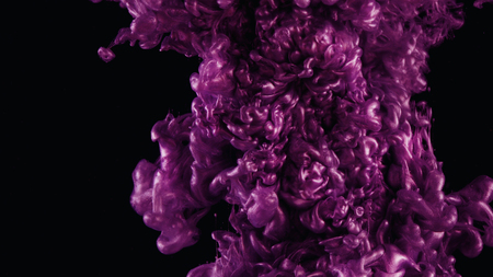 Ink in water. Colour pink glitter paint reacting in water creating abstract cloud formations.の写真素材