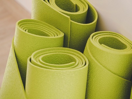 close up of green yoga mats in fitness studio, sport and healthy concept. film fade filter.の写真素材