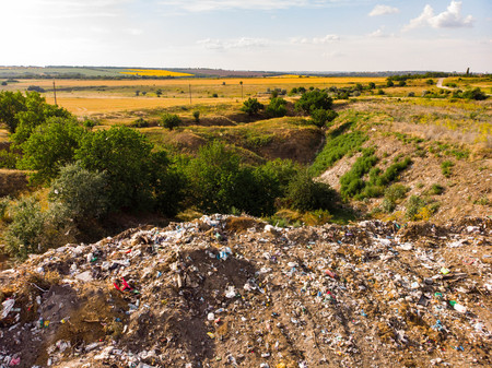 City Dump concept. Aerial Drone View. Environmental pollution. Plastic bottles, bags, trash in green field. Nature polluted from activities of irresponsible people.の写真素材