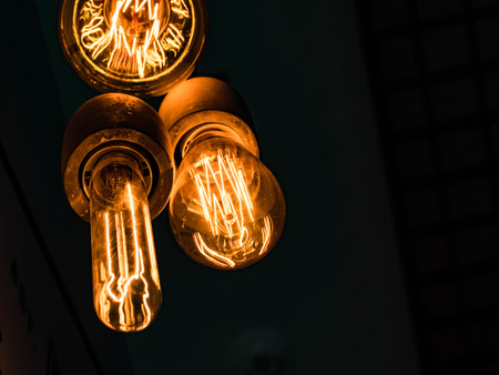 Different types of vintage glowing light bulbs on black. Edison lampsの写真素材