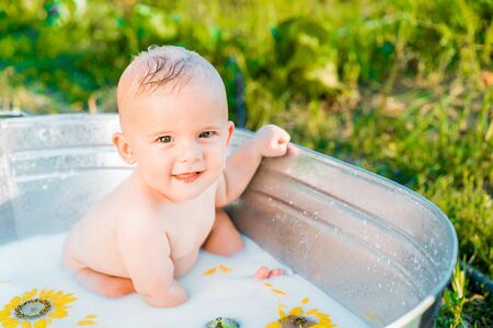 Cute little baby boy portrait in milk bath with sunflowers. Healthy lifestyle. child in summer garden, nature concept.の写真素材