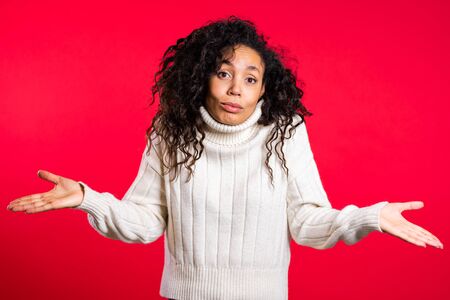 unsure african girl shrugs her arms, makes gesture of I dont know
