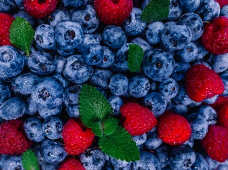 Fresh raspberries and blueberries great bilberry background. Healthy food organic nutrition. Top view from aboveの写真素材
