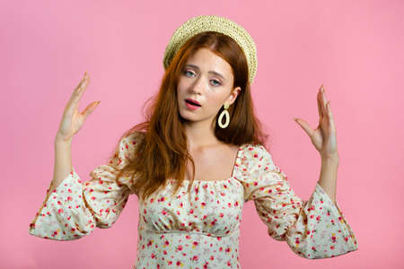 Cute girl showing bla-bla-bla gesture with hands and rolling eyes isolated on pink background. Empty...
