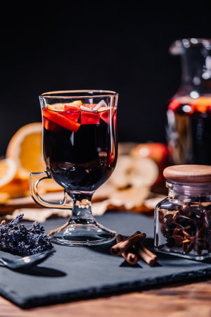 Still life - mulled wine, hot red wine with spices in glass among fruits. Scented cozy Christmas celebration, fragrant punch concept.の写真素材