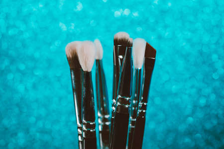 Cosmetics make-up brushes on blue sparkling background.の写真素材