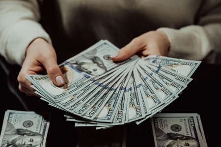 Woman is counting cash money - salary or other income. Close-up of hands with banknotesの写真素材