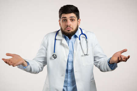 Unsure doctor man in medical coat shrugs his arms, makes gesture of I dont know, care, cant help...