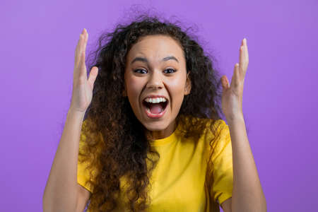 Mixed race woman is very glad, she screaming loud. Concept of sales, profitable offer. Excited happy...