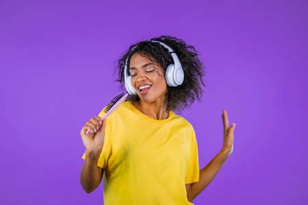 African teenager with problem skin - acne singing with hair brush or comb instead microphone at...