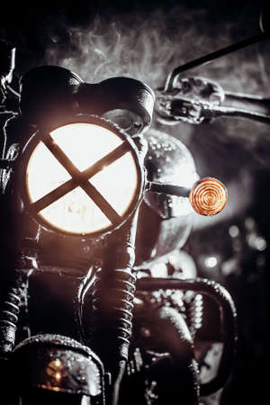 Silhouette of black retro styled motorcycle scrambler at night in fog. Adventure, motor vehicle, custom motorbike concept. Dark night with hazeの写真素材
