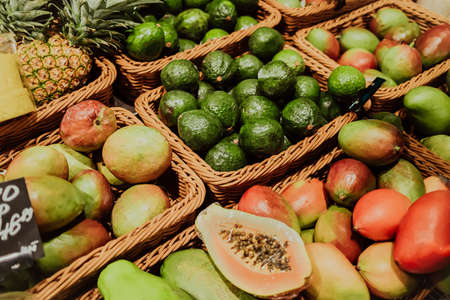 Supermarket counter with healthy tropical fruits. Avocado, mango, papaya, pineapple