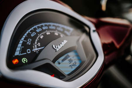 Corfu, Greece - September 2021. Dashboard of modern motor bike or scooter Vespa in red color....