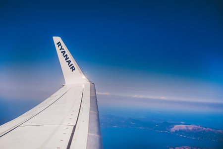 Corfu, Greece - September, 2021. View from Ryanair jet to paradise islands in ocean. Camera filming from aircraft porthole. Earth landscape and sea through window.のeditorial素材