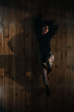 Top view to sexy woman lying on floor. Seductive dance in studio. Lady dancer in tight clothes and heels. Top view.の写真素材