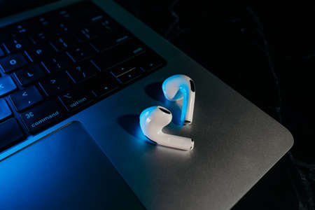 Barcelona, Spain - January 2022. New airpods pro on apple laptop. Wireless compact headphones....