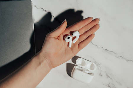 Barcelona, Spain - January 2022. New airpods pro in female hand. Wireless compact headphones. Music,...