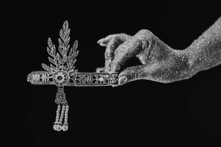 Woman holding beautiful crown on black background. Fantasy wedding diamond corona, roaring twenties time, luxury retro jewelry concept.の写真素材