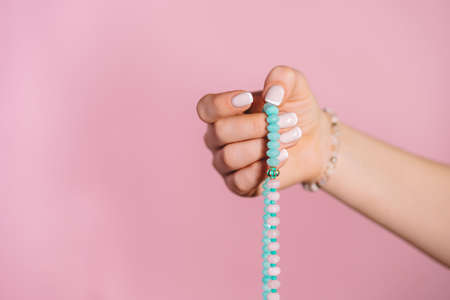 Woman lit hand counts mala beads strands of gemstones used for keeping count during mantra...