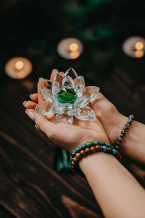 Woman holding fragile crystal lotus flower. Concept of religion, art, meditation, chakras, spiritual...