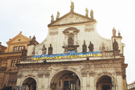 Prague, Czech Republic - July 2022. Church of St. Salvator with hands off Ukraine putin sign on facade in support. Historic complex Clementinum. Baroque details architecture.のeditorial素材