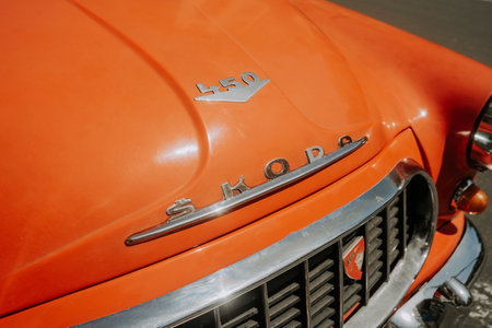 Prague, CZECH REPUBLIC - July 2022. Detail of retro Skoda automobile brand, logo close-up view. 450 orange roadster. Symbol of Czech vintage car maker and producerのeditorial素材