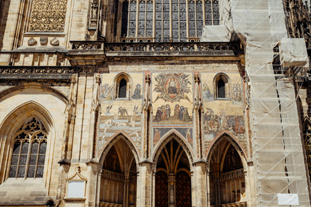 Prague, Czech Republic - July 2022. Facade of entrance St. Vitus cathedral. Architecture in gothic style, details of masterpiece religious mosaic depicting Last Judgment above golden gate.のeditorial素材