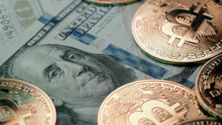 Bitcoin, crypto currency. Golden coins on bills of 100 usd, dollars. Digital exchange, popularity of...