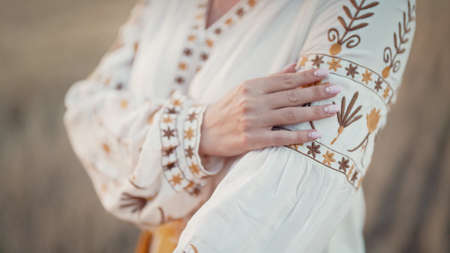 Ukrainian woman showing embroidery ornament, beautiful details of vyshyvanka shirt. National costume - embroidered shirt, texture, design, folk, handmade craft needleworkの写真素材