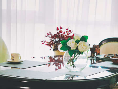 White roses in vase on kitchen table. Beautiful interior design.