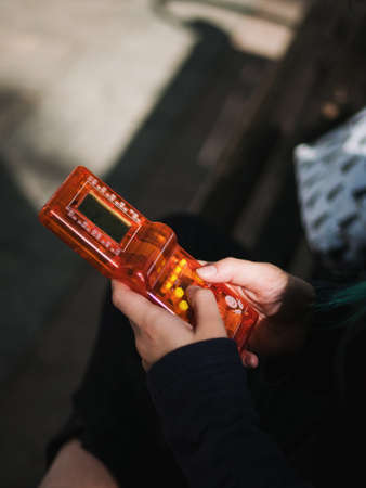 Hands of hipster girl playing tetris game in European park. Old school concept.の写真素材