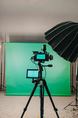 Modern studio with professional video camera and green screen - chromakey. TV camera for recording...