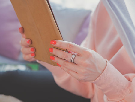 Hands of woman using tablet computer touchscreen at her cozy home. Female hands with digital map-case in bed. Technology, education conceptの写真素材