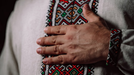 Man demonstrating geometric details of embroidery ornament on vyshyvanka shirt. National costume - embroidered shirt, texture, design, folk, handmade craft needleworkの写真素材