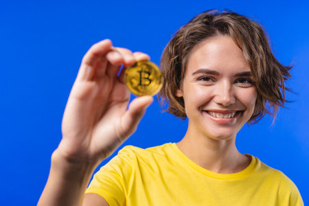 Woman with bitcoin, crypto currency. Golden coin on blue background. Digital exchange, popularity of BTC, symbol of future money, electronics industry, mining concept.の写真素材