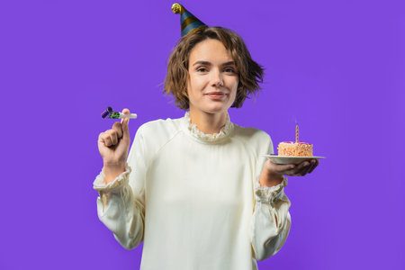 Happy birthday woman making wish - candle on cake. Girl smiling, celebrating anniversary. Young...