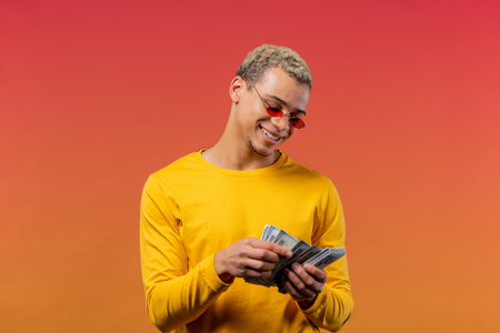 Satisfied man counting USD currency. Young millenial guy or student counts money - dollars banknotes...