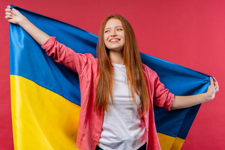 Happy woman with national Ukrainian flag on pink. Ukraine, patriot, victory in war celebration, banner, Independence dayの写真素材