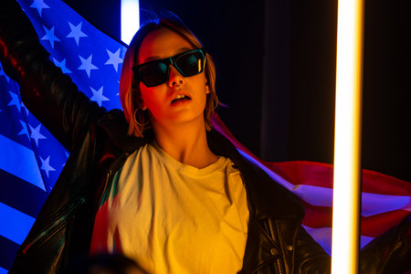 Happy dancing woman with national USA flag. American patriot, 4th of Julyの写真素材