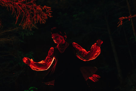 Dancing woman in traditional ukrainian handkerchief costume on dark night forestの写真素材