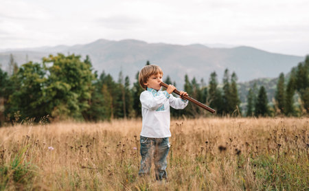 Folk music. Little boy playing on woodwind wooden flute - ukrainian sopilkaの写真素材