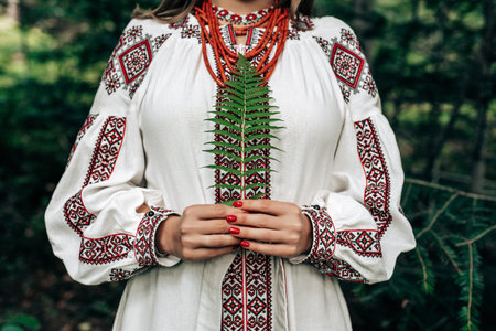 Authentic woman in traditional ukrainian costume with fern in forest.の写真素材