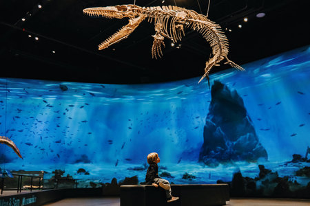 October 2023 - Prague, Czechia. Little boy, kid in Dinosaur museum exhibition.のeditorial素材