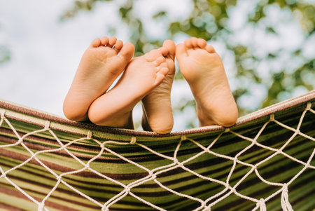 Feet of children, which swinging on hammock at summer.Kids relax,happy childhoodの写真素材