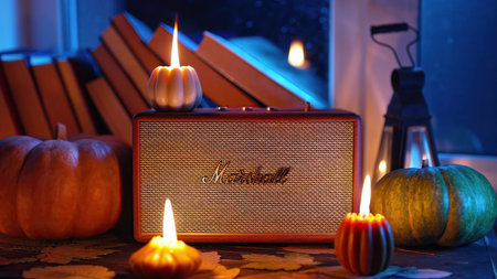 Kyiv, Ukraine - November 2023. Autumn music ambience. Marshall bluetooth speaker Acton III among candles, books near rainy window.のeditorial素材