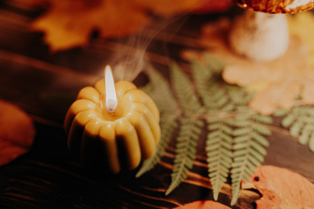 Autumn background. Pumpkin candle burning, fallen leaves. Quiet moments, hyggeの写真素材