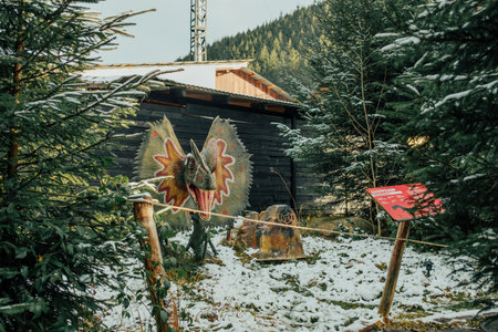 Bukovel, Ukraine - December 2023. Attraction statue of dinosaurs model in Dinopark, winter forest park in natureのeditorial素材