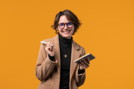 Businesswoman writing notes in planner with pen. Pretty lady thinking, diaryの写真素材