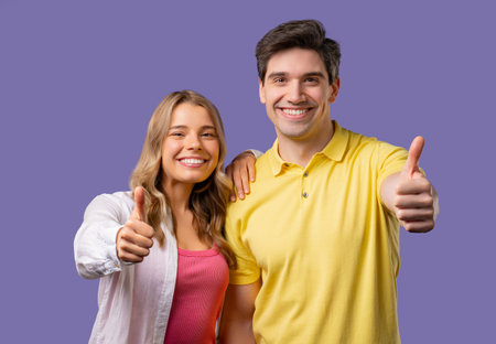 Positive woman and man with hand sign like, thumbs up gesture. Couple on violetの写真素材